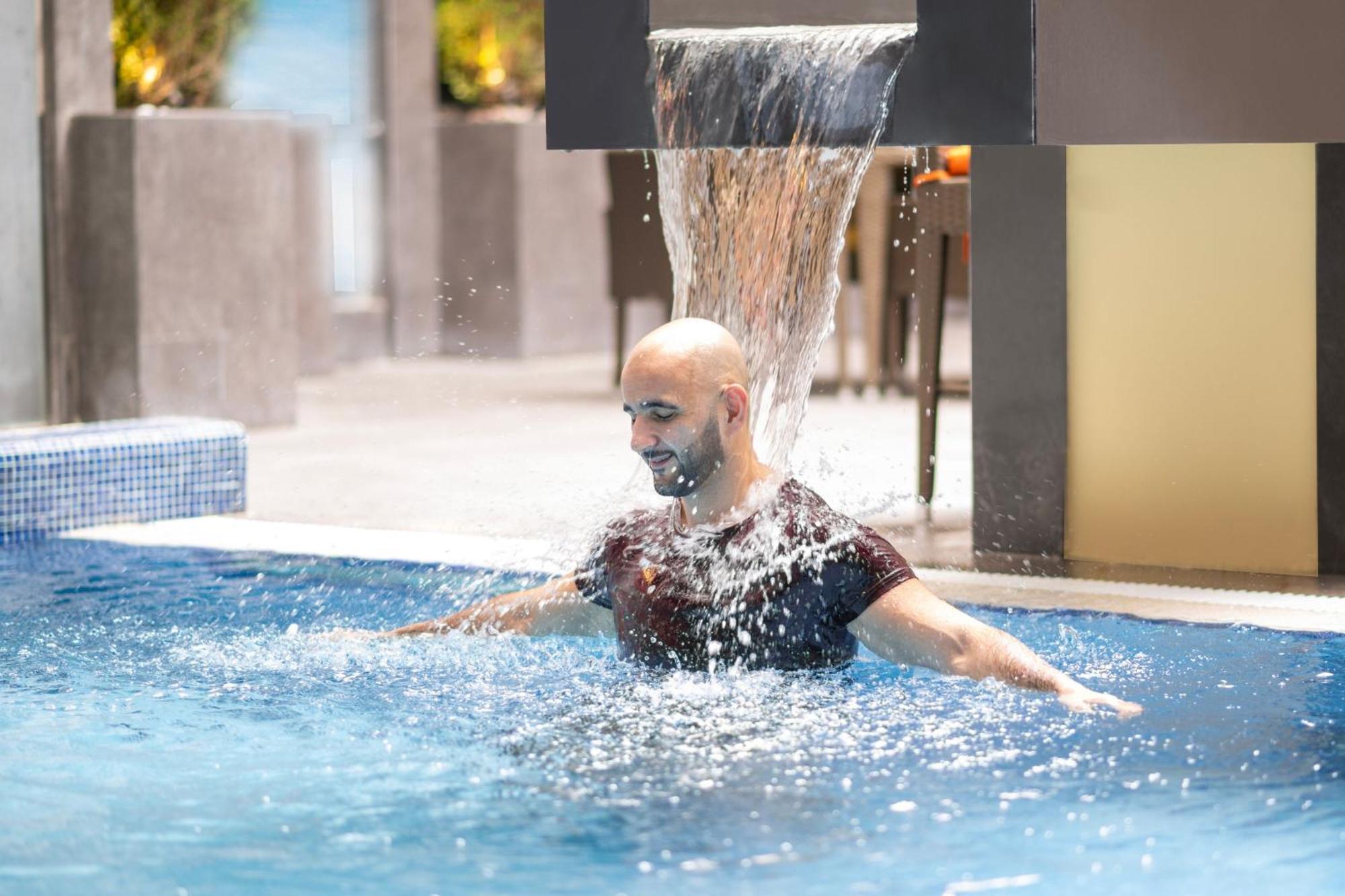 Delta Hotels By Marriott City Center Doha Exterior foto A man swimming in a pool