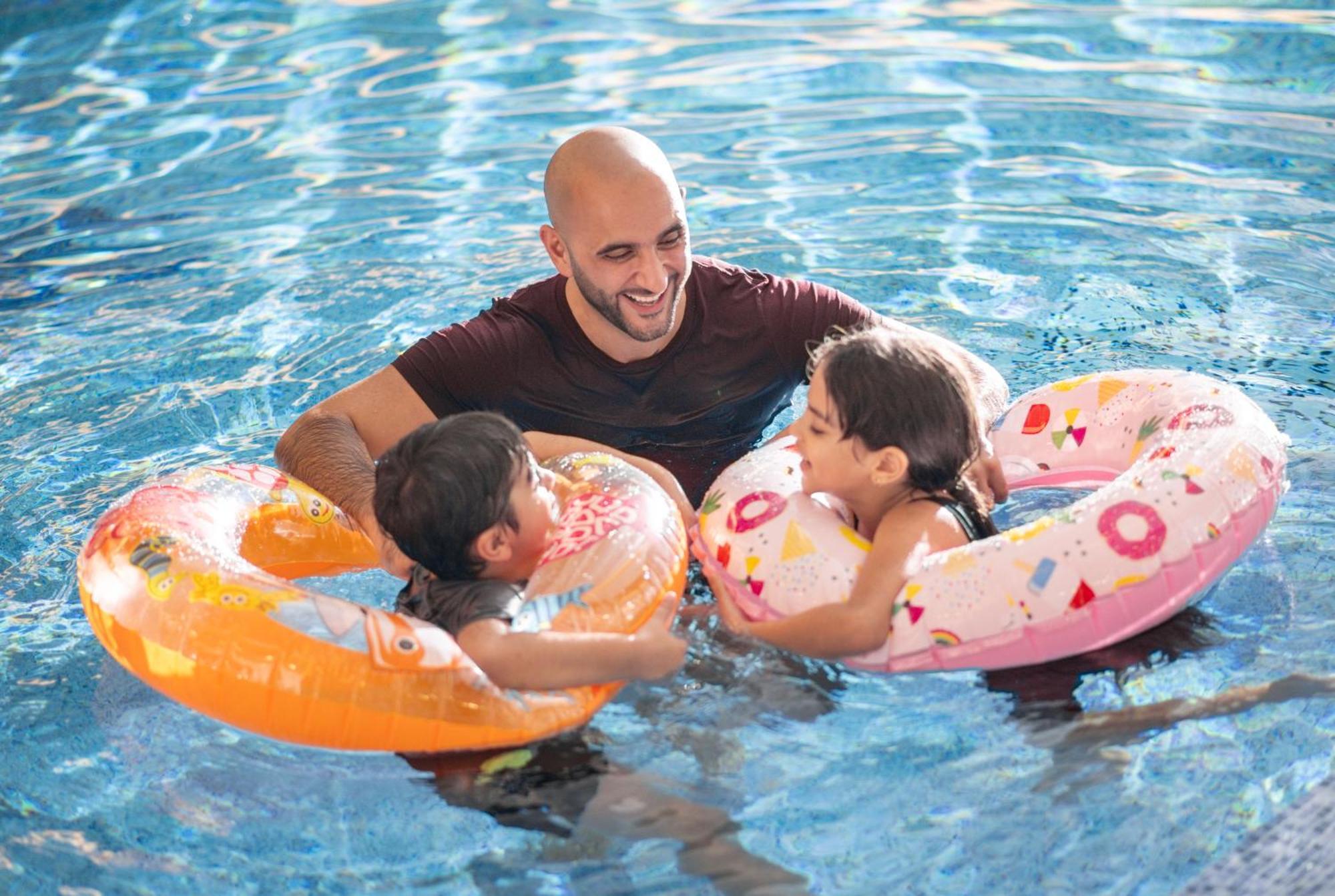 Delta Hotels By Marriott City Center Doha Exterior foto A father and two children in a swimming pool